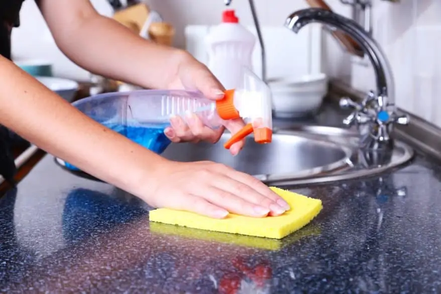 Cleaning kitchen with spray and sponge