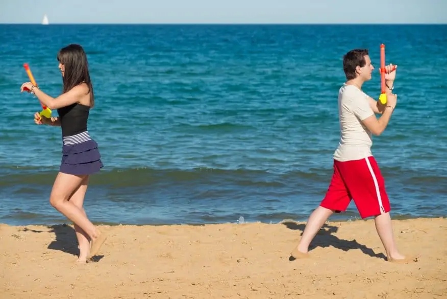 Couple walking away from each other to start a water gun duel