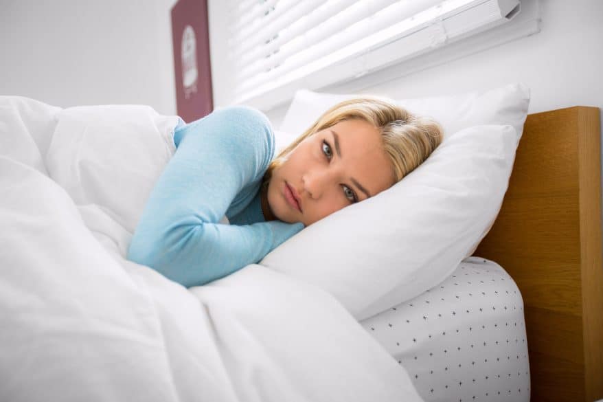 Woman in bed with eyes open insomnia can't sleep during daytime anxiety