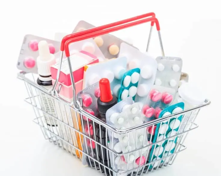 Basket with colorful pills on white background