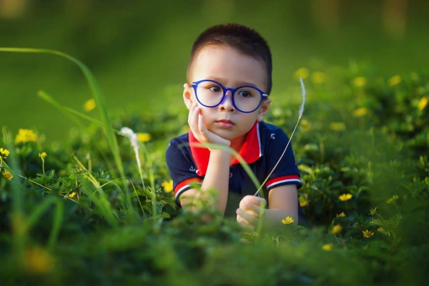 boy in the grass blue glasses