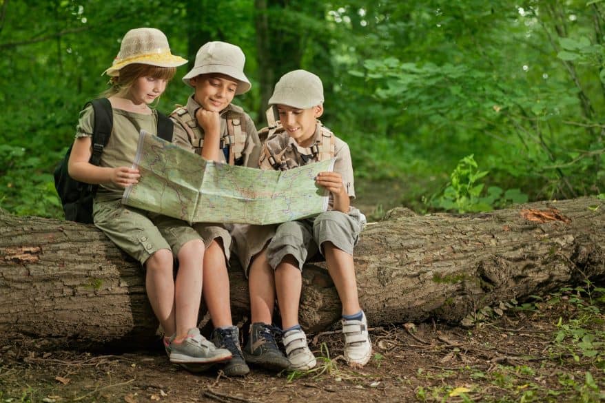 kids looking at a map while hiking