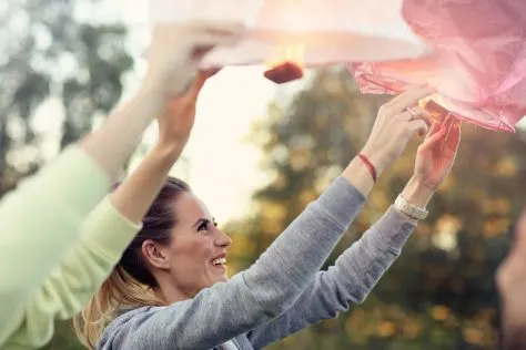 Picture showing group of friends floating chinese lanterns