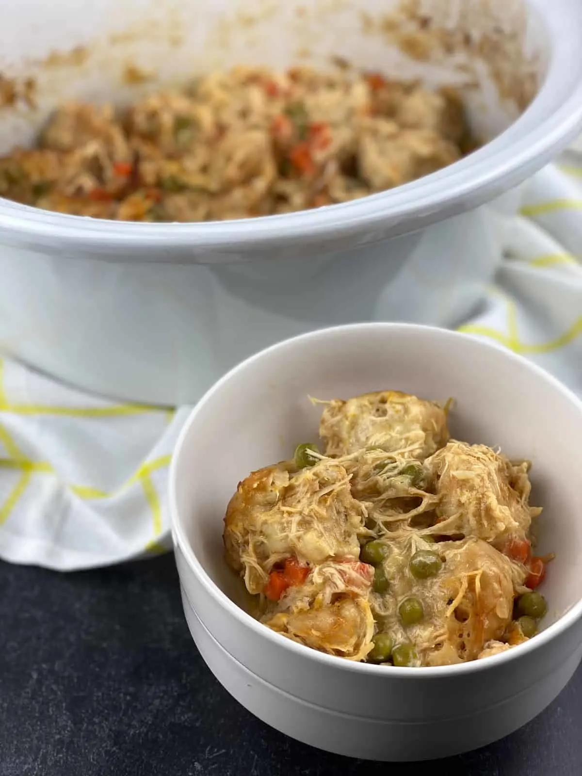 crock pot insert with bowl of chicken and dumplings made with canned biscuits