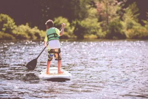 Boy paddleboarding staycation activity ideas