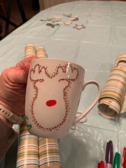 A dotted Rudolph mug with a red nose.