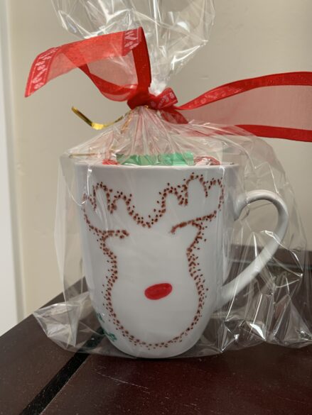 A finished and wrapped mug with a dotted reindeer on it.