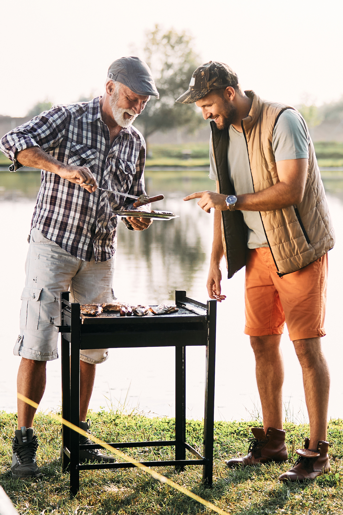 adult father and son grilling on trip