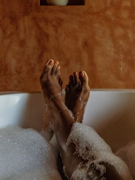 Feet sticking out of a bubble bath.