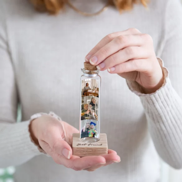 A strip of photo booth pictures inside a bottle.