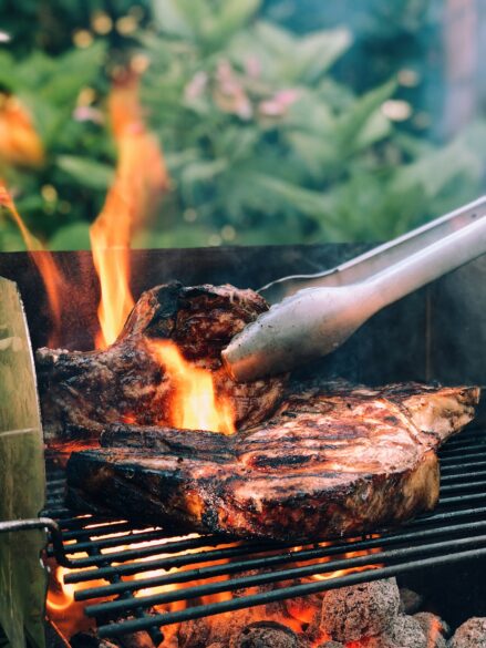 Flipping over meat on a grill.