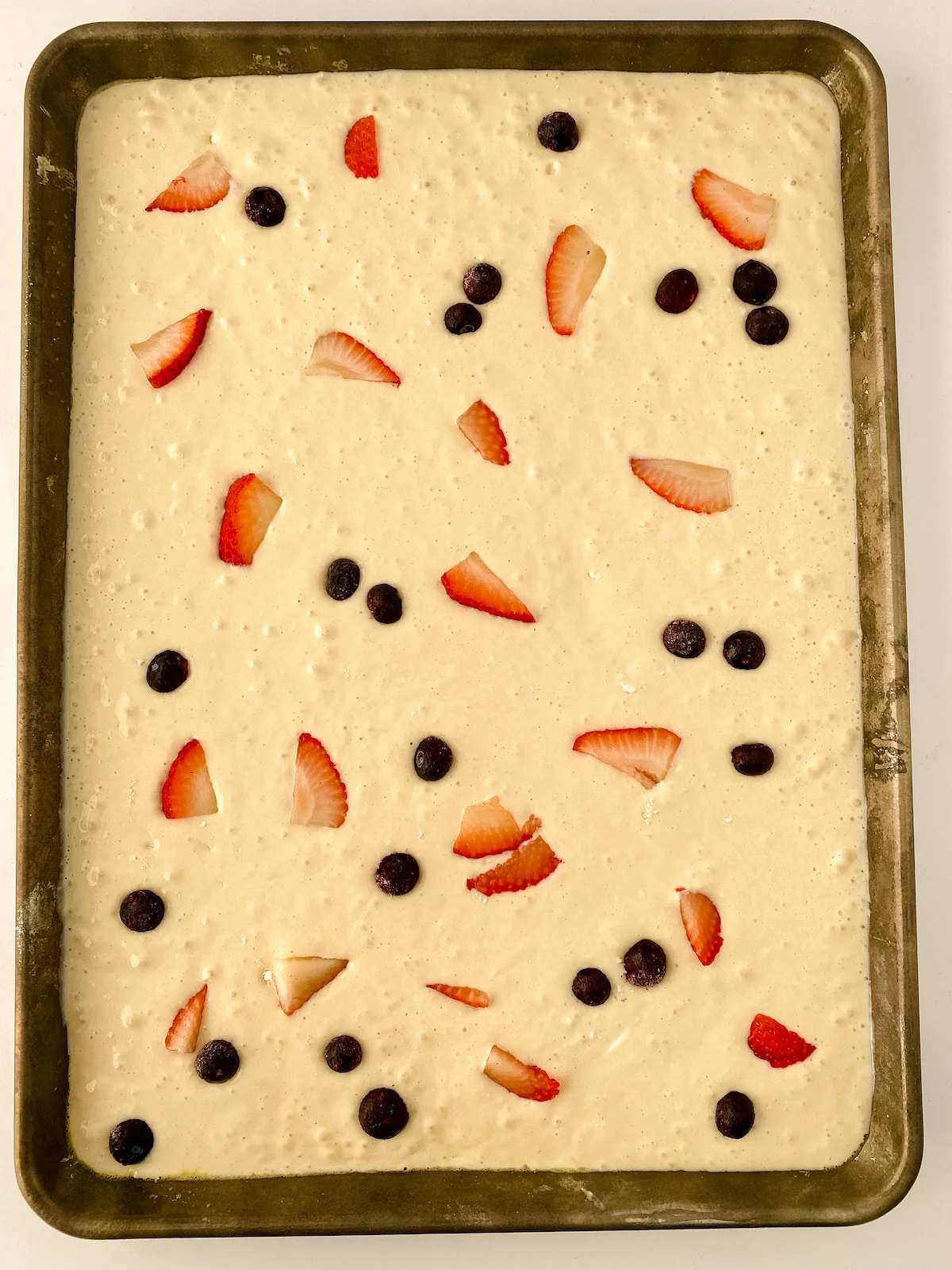 sheet pan pancakes with toppings before going in the oven