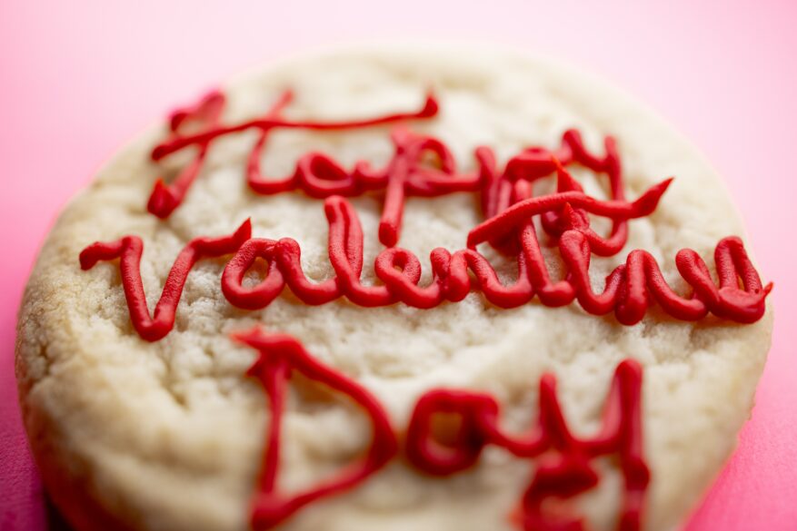 "Happy Valentines Day" written on a cookie with frosting
