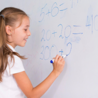 girl doing math on white board; how to teach math to homeschoolers