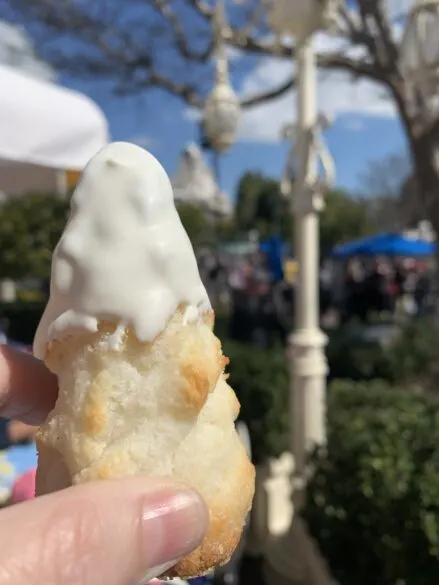 A Matterhorn macaroon being held up in front of the Matterhorn ride.