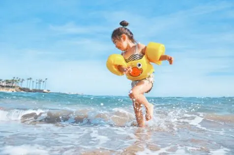 girl splashing in the ocean; Fun Family Water Activities