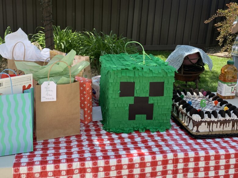 Piñata on a table with cake and gifts.