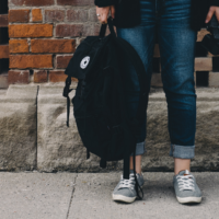 child holding backpack