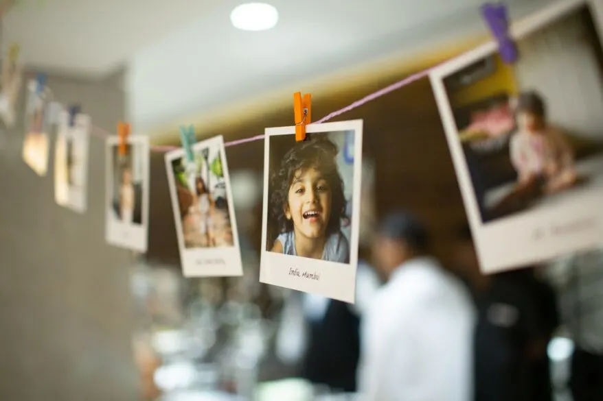 Polaroid pictures hanging on a string with clothespins.