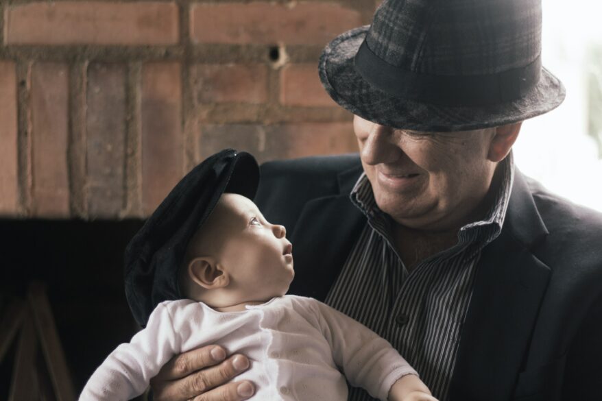 A grandpa and a baby looking at each other.