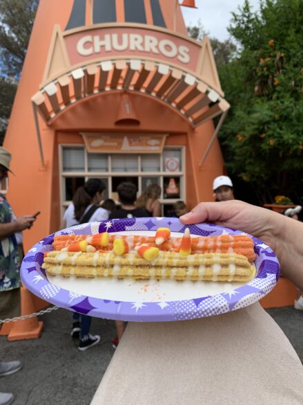 The Candy Corn Churro in front of the churros Cozy Cone.