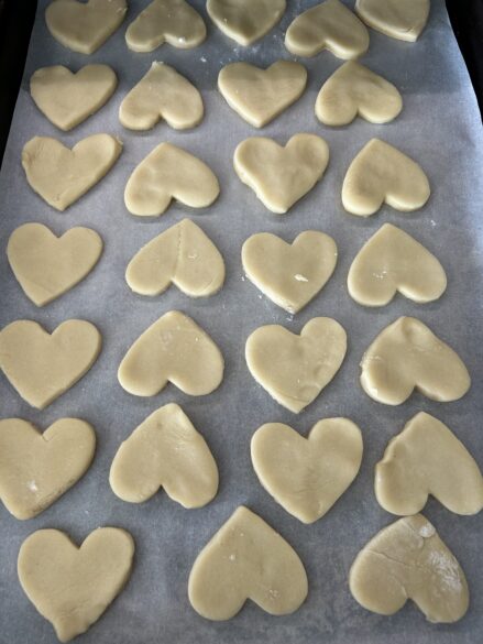 A pan of heart shaped cookies ready to go in the oven.